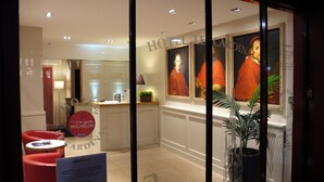 A hotel lobby with a reception desk, a red chair, and a sign for Michelin 2015.