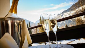 A bottle and two glasses on a balcony with a mountain view. - EUROPÄISCHER HOF Bad Gastein (Bad Gastein)