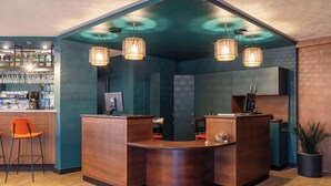 A bar area with a curved counter, two bar stools, and hanging pendant lights. - Le Carline, Sure Hotel Collection by Best Western (Caen)