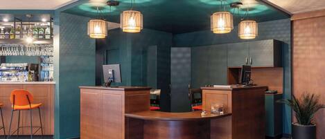 A bar area with a curved counter, two bar stools, and hanging pendant lights.