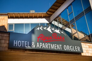 Señal para el Hotel & Apartamentos AlpenPark Orglr con un diseño de montaña.
