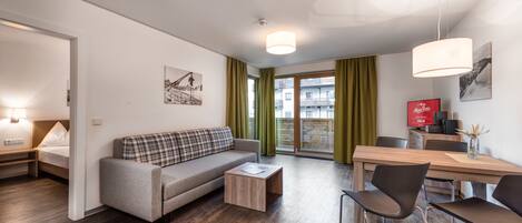 En moderne stue med sofa, sofabord og spiseplads.