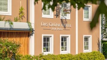 A hotel facade with the name 'Das Grüne Hotel' and 'Zur Post' signage.