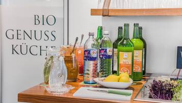 Zona de bar con botellas, vasos y un cartel que dice 'BIO GENUSS KÜCHE'.