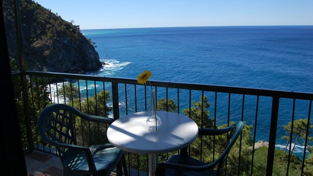 A balcony with a table and chairs overlooking the ocean. - Resort La Francesca (Bonassola)