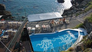 A pool with an octopus design, surrounded by lounge chairs and a covered area. - Resort La Francesca (Bonassola)