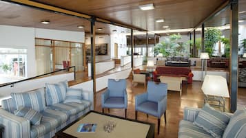Amplia sala de estar con sofás a rayas, sillones y una mesa de centro.