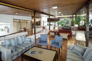 A spacious living area with striped sofas, armchairs, and a coffee table.