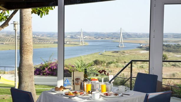 A breakfast table with a scenic view of a bridge over a river. - Parador de Ayamonte (Ayamonte)