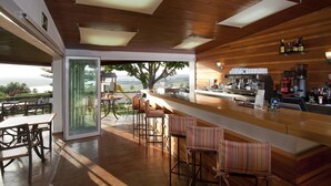 A modern bar area with wooden ceiling, a bar counter, and seating. - Parador de Ayamonte (Ayamonte)