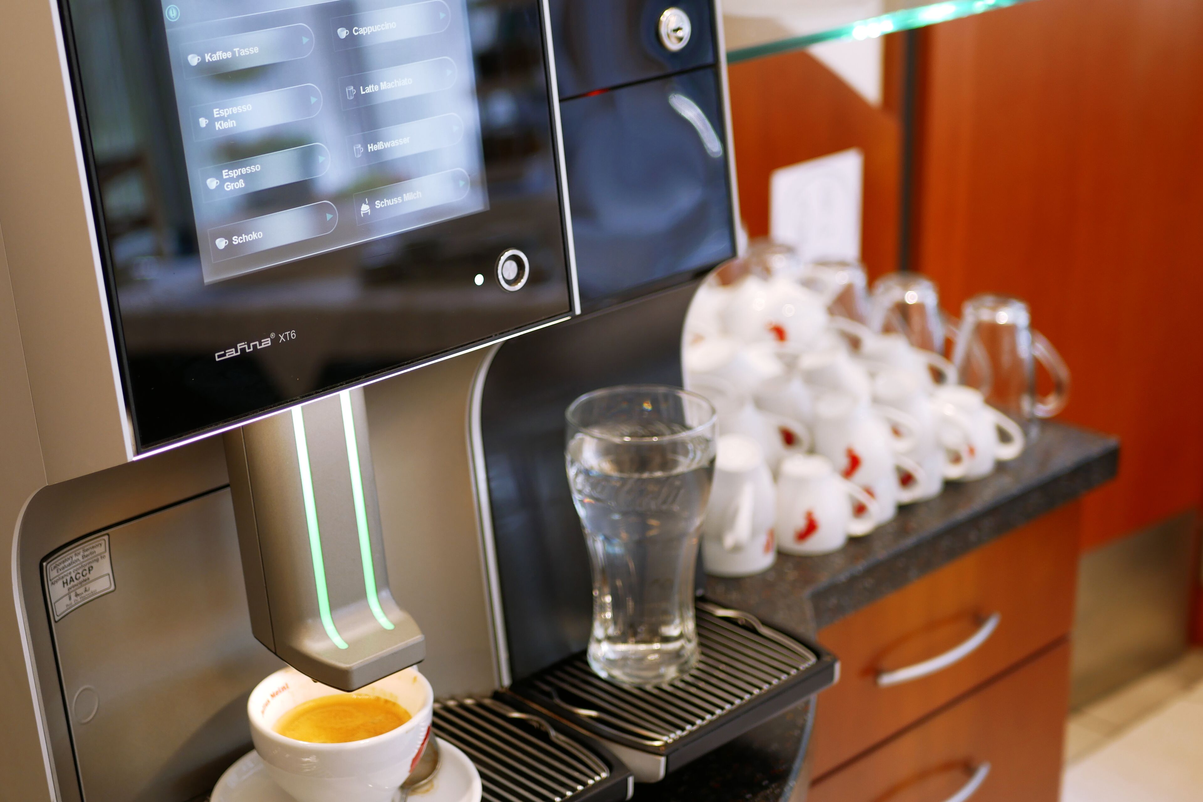 A coffee machine with a digital interface displaying various coffee options.