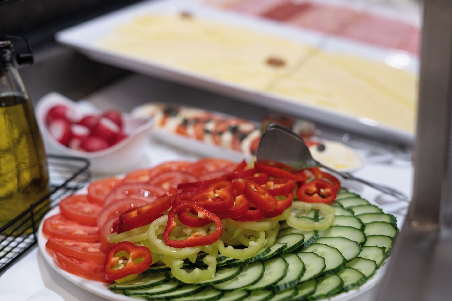 A salad with tomatoes, cucumbers, and red peppers on a plate.