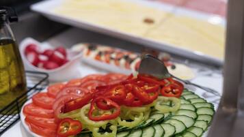 A salad with tomatoes, cucumbers, and red peppers on a plate.