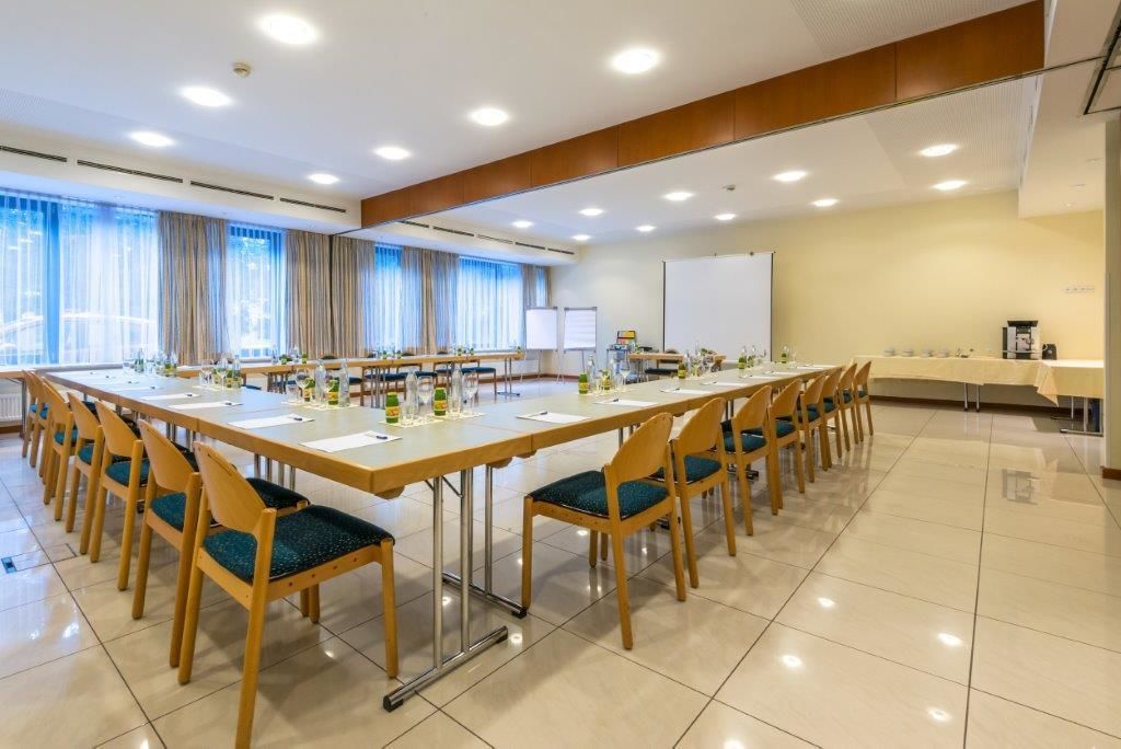 A conference room with a long table, chairs, and a whiteboard.