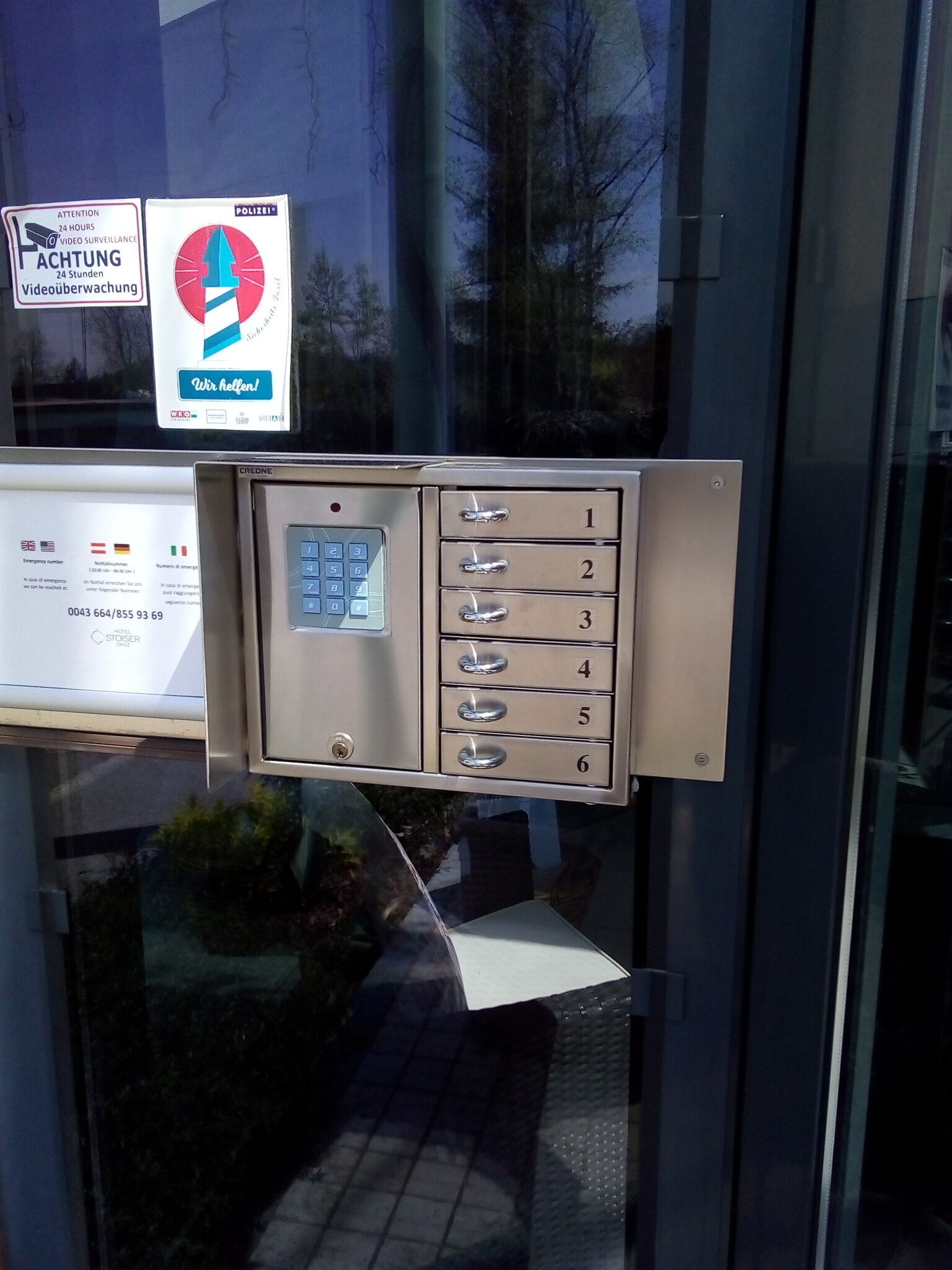 A hotel room's entry system with a keypad and numbered drawers.