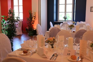 A dining table set with white tablecloths, glassware, and numbered place cards. - SPA Hotel Erzherzog Johann (Bad Aussee)