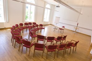 A conference room with a circular arrangement of chairs, a projector, and a whiteboard. - SPA Hotel Erzherzog Johann (Bad Aussee)