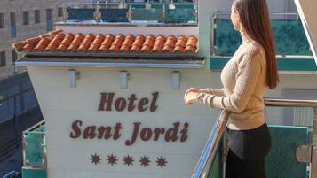 Un letrero del Hotel Sant Jordi con tejado de azulejos y barandilla de balcón.