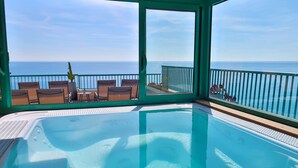 A hot tub with a view of the ocean, surrounded by chairs and a railing. - Princess et Richmond (Menton)