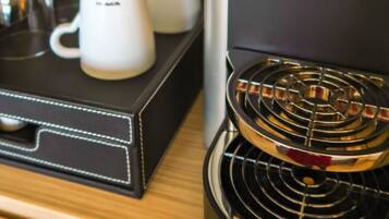 A coffee machine with a water reservoir, a drip tray, and a coffee pot.