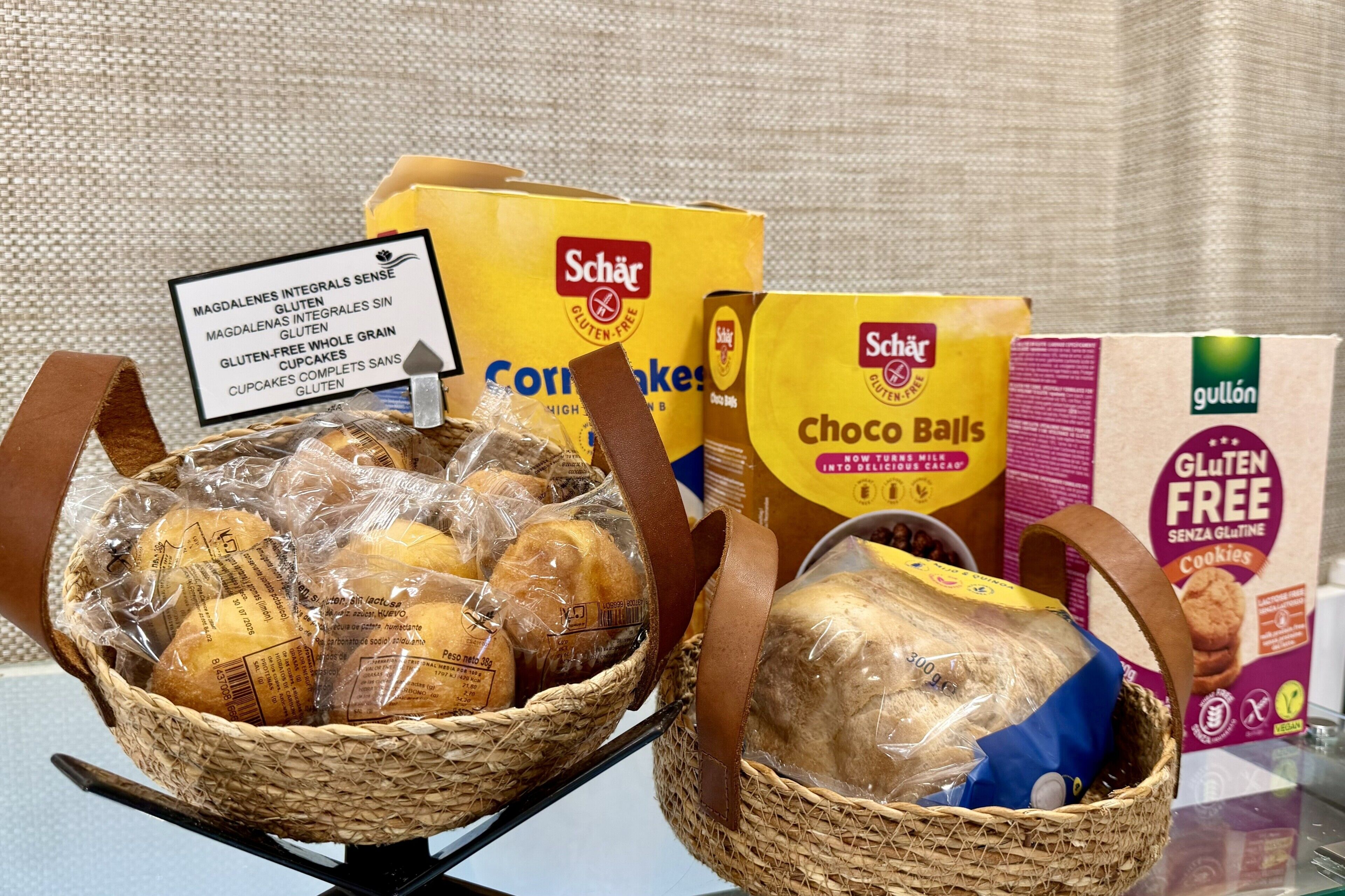 A basket of bread and chocolate balls, gluten-free packaging, and a sign indicating gluten-free products.