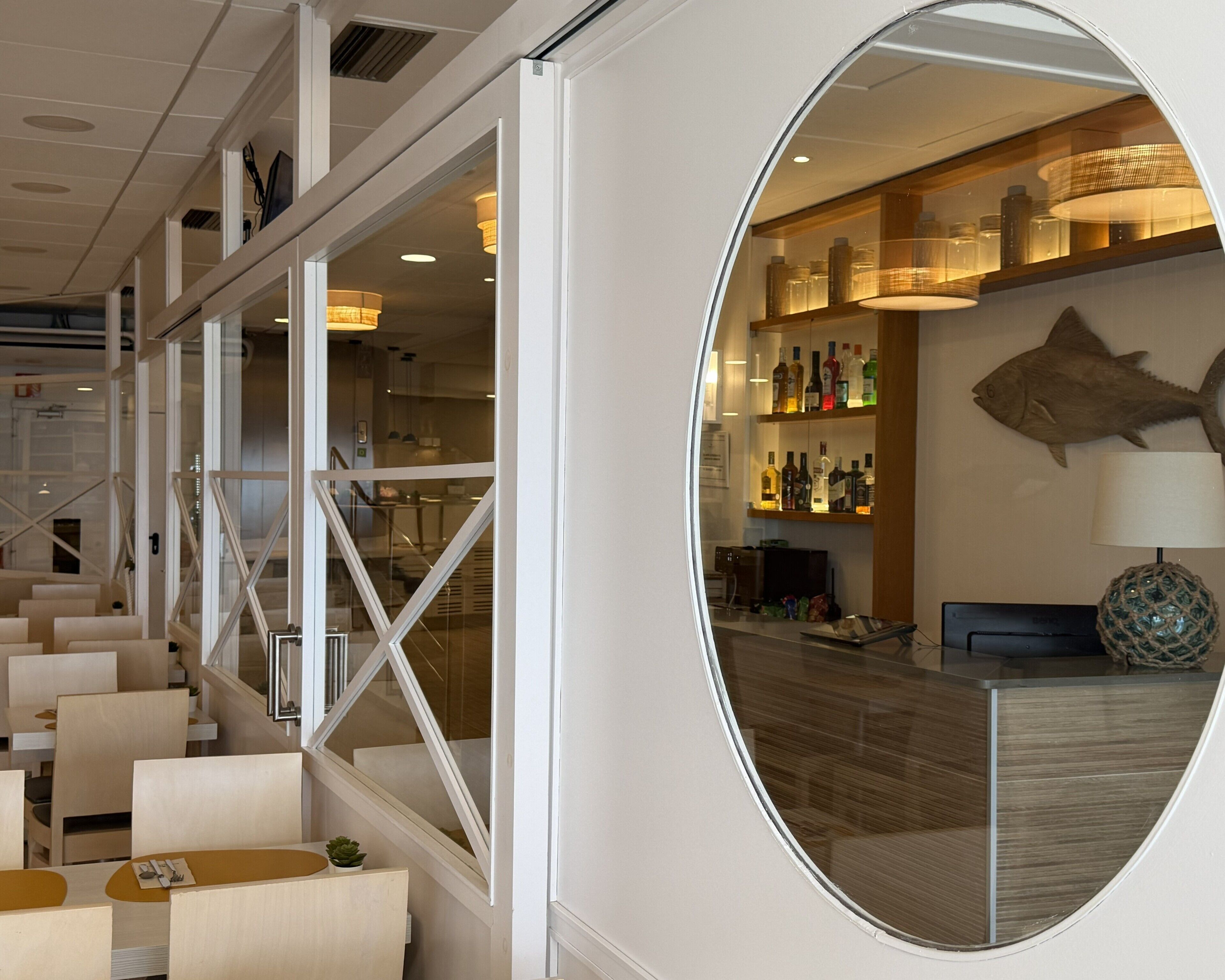 A modern interior with a staircase, seating area, and a bar with a fish decoration.