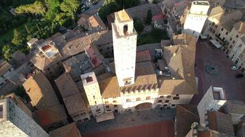 Una vista aerea di una città storica con una torre imponente, strade strette e edifici tradizionali.