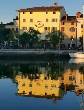 Hotel al Lago delle Fate & Frane offers a serene lakeside setting with a boat docked in front.