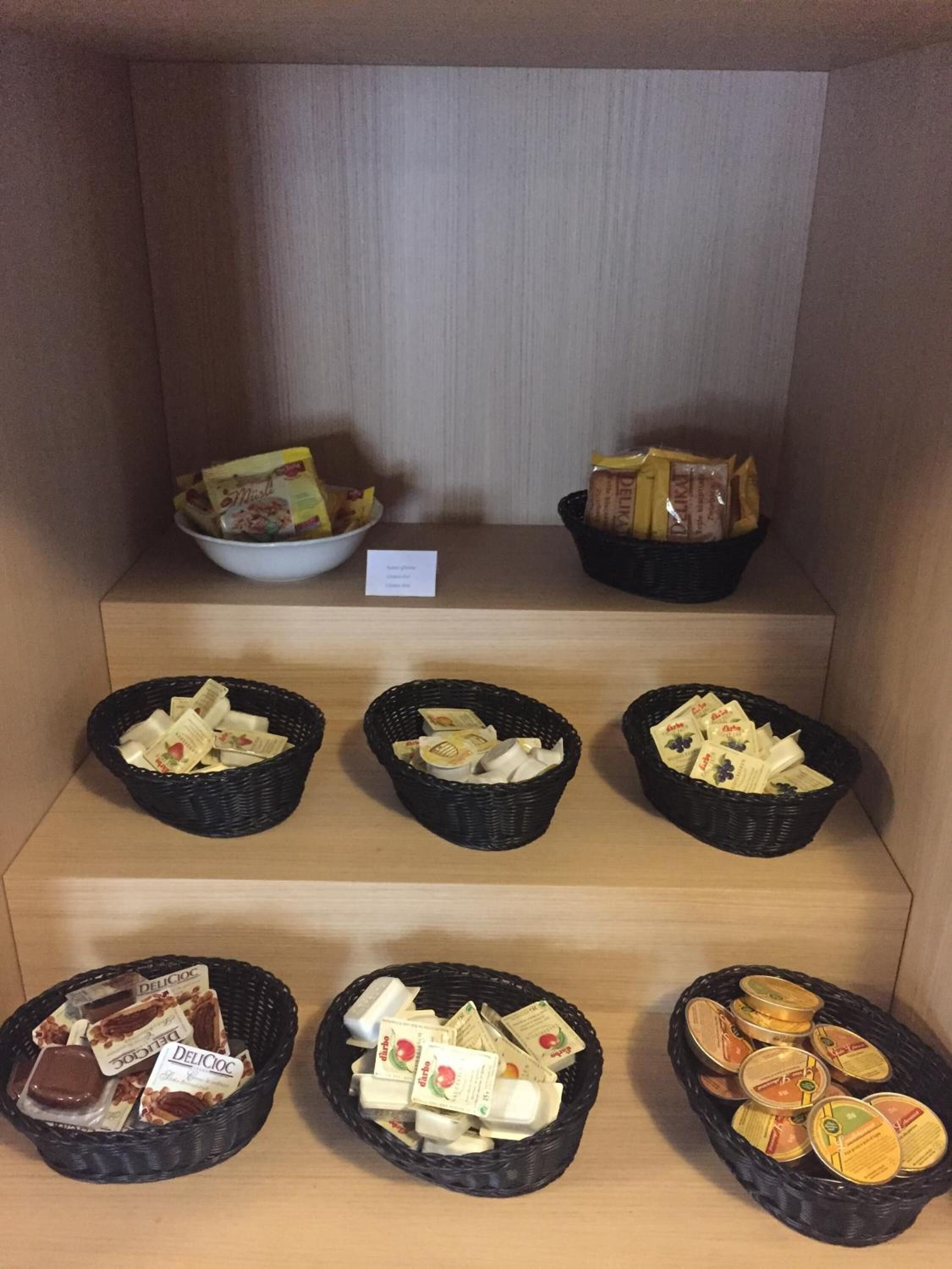 A display of various food items in baskets and bowls, including packaged snacks and bread.