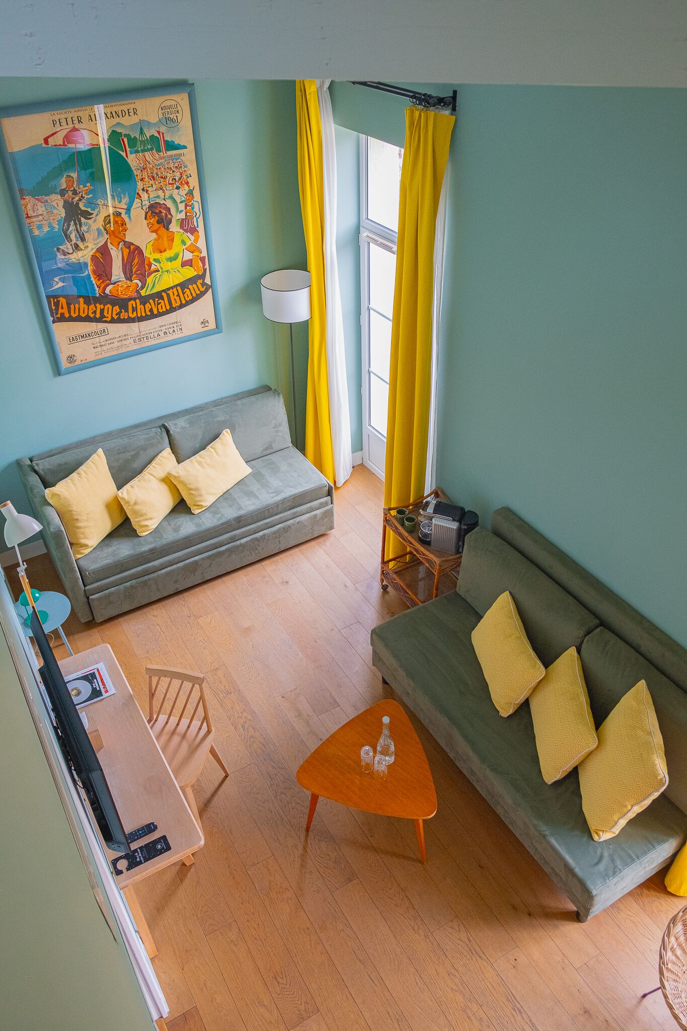 A living room with two sofas, a wooden coffee table, and a poster on the wall.