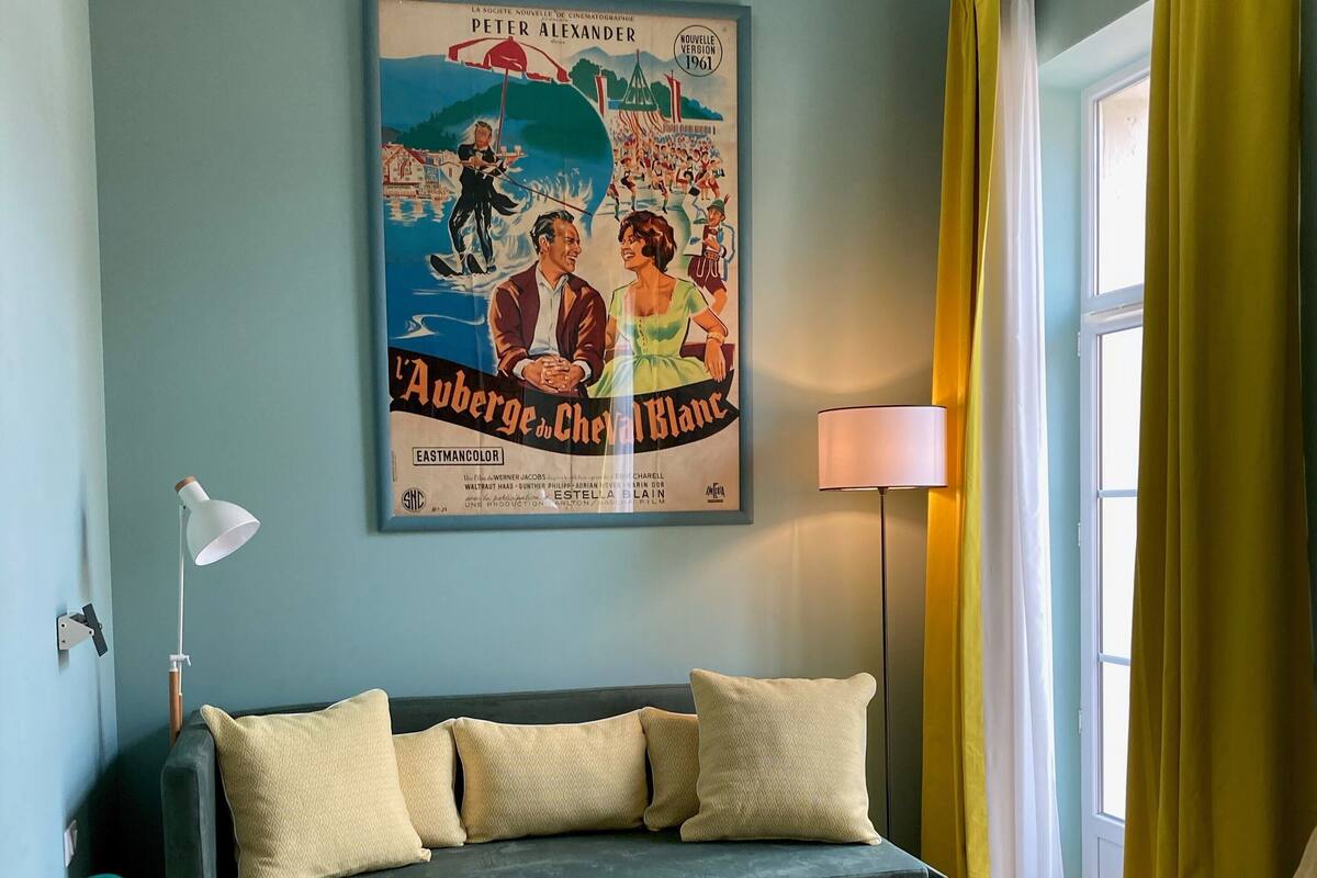 A living room with a green sofa, a wooden coffee table, and a poster on the wall.