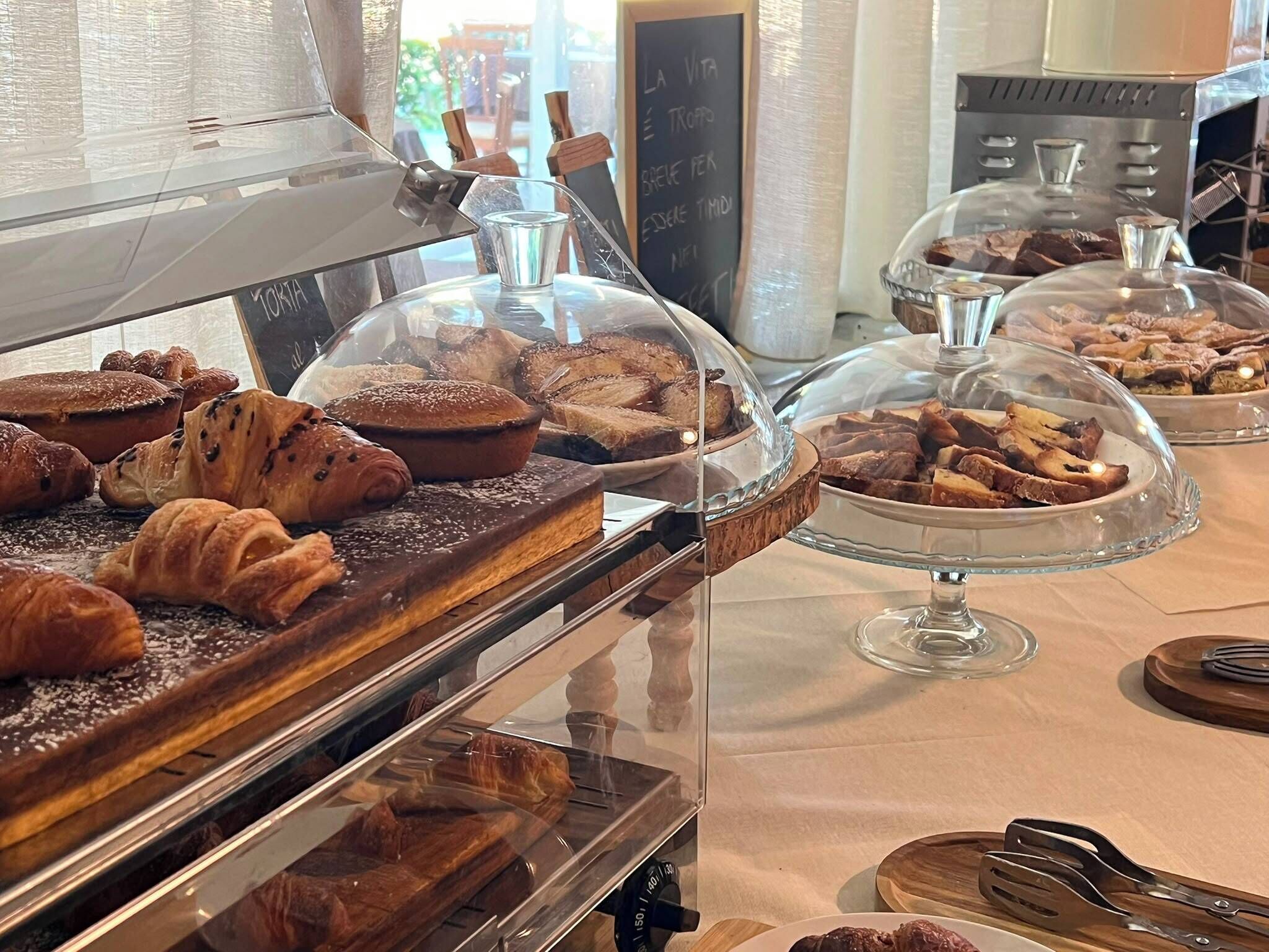 Eine Bäckereireihe mit verschiedenen Backwaren unter Glasplatten.