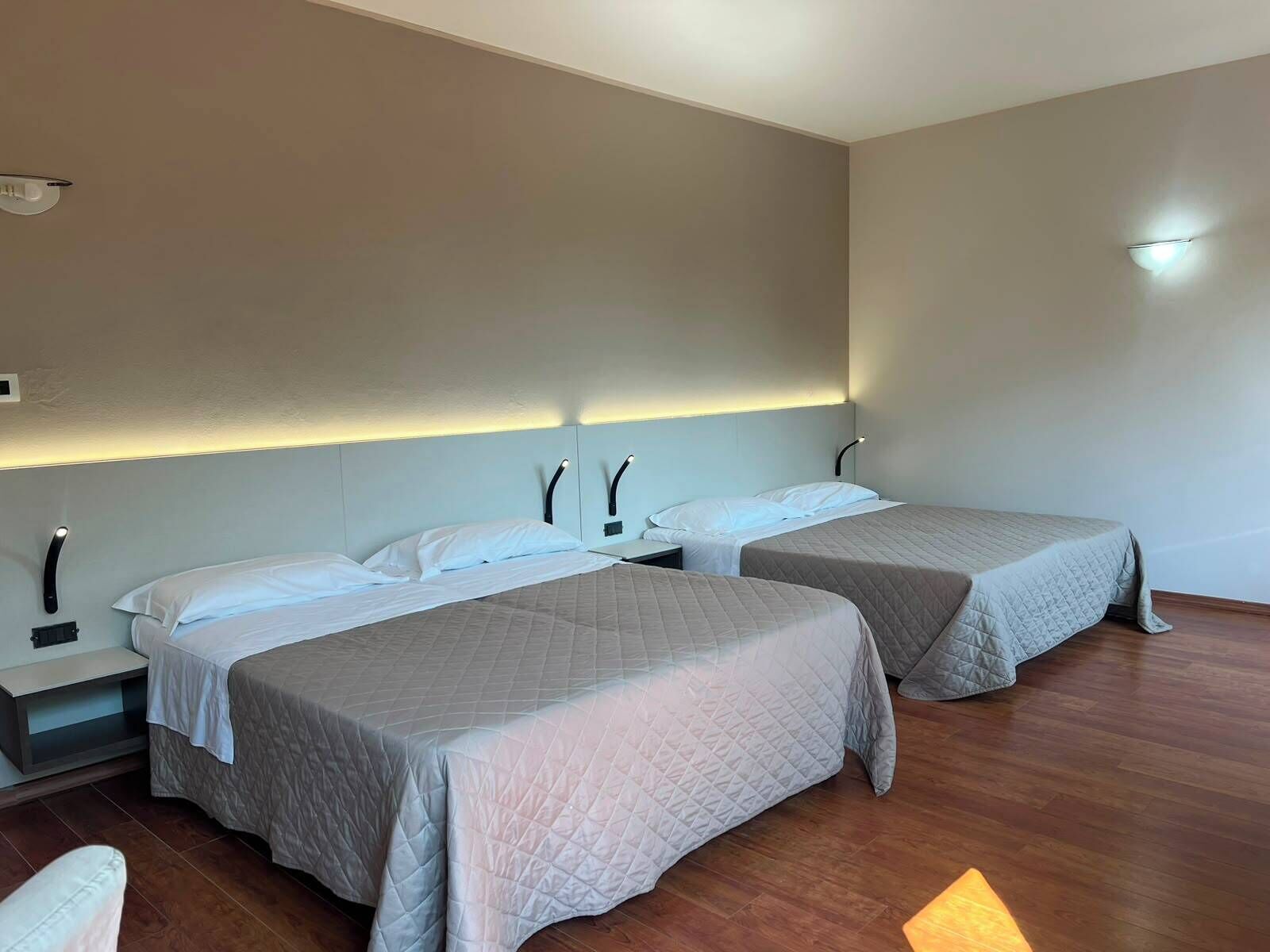 Une chambre d’hôtel avec deux lits, une table de chevet et une petite table.