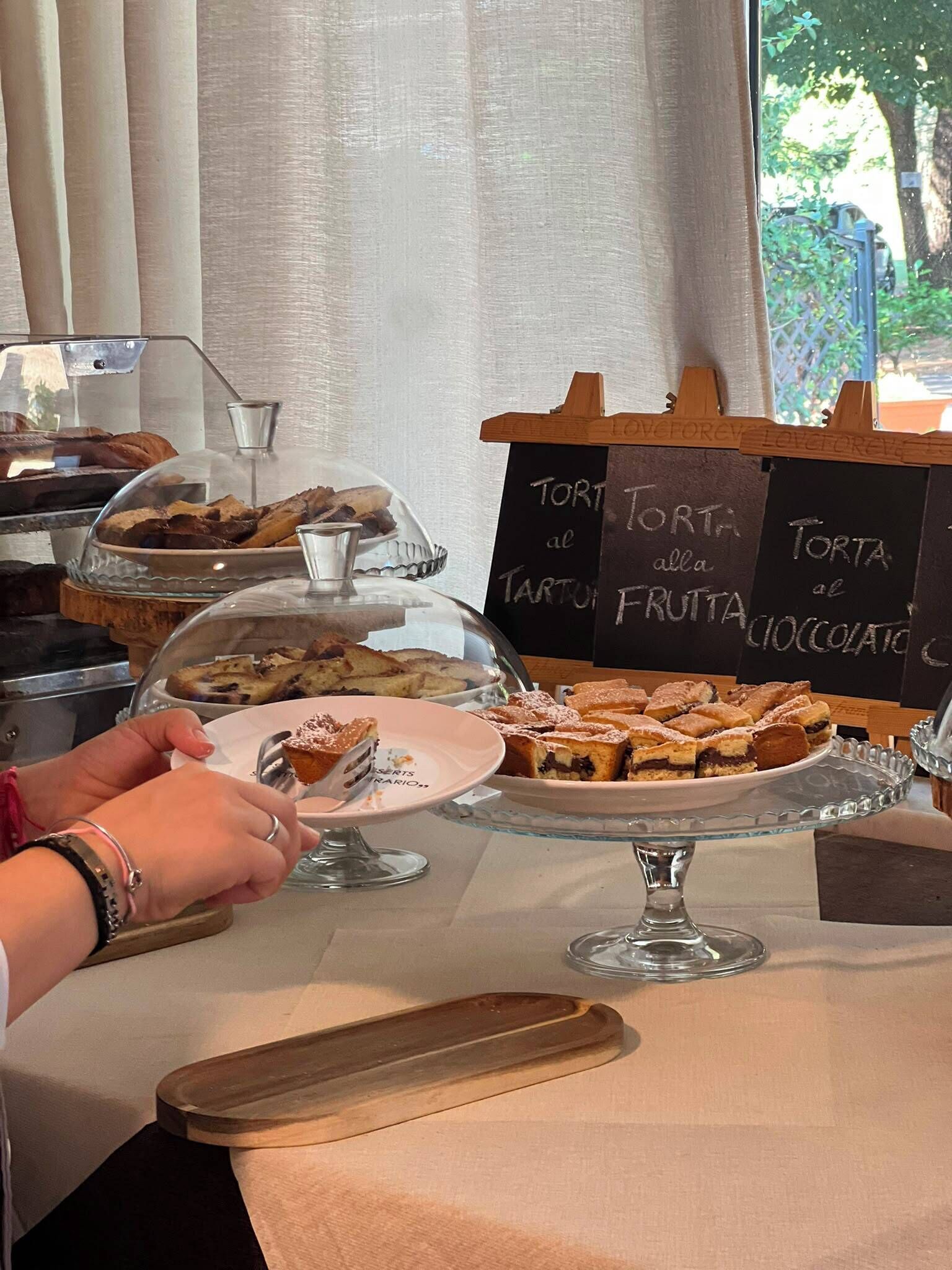 Una mesa con postres variados y un menú en una pizarra.