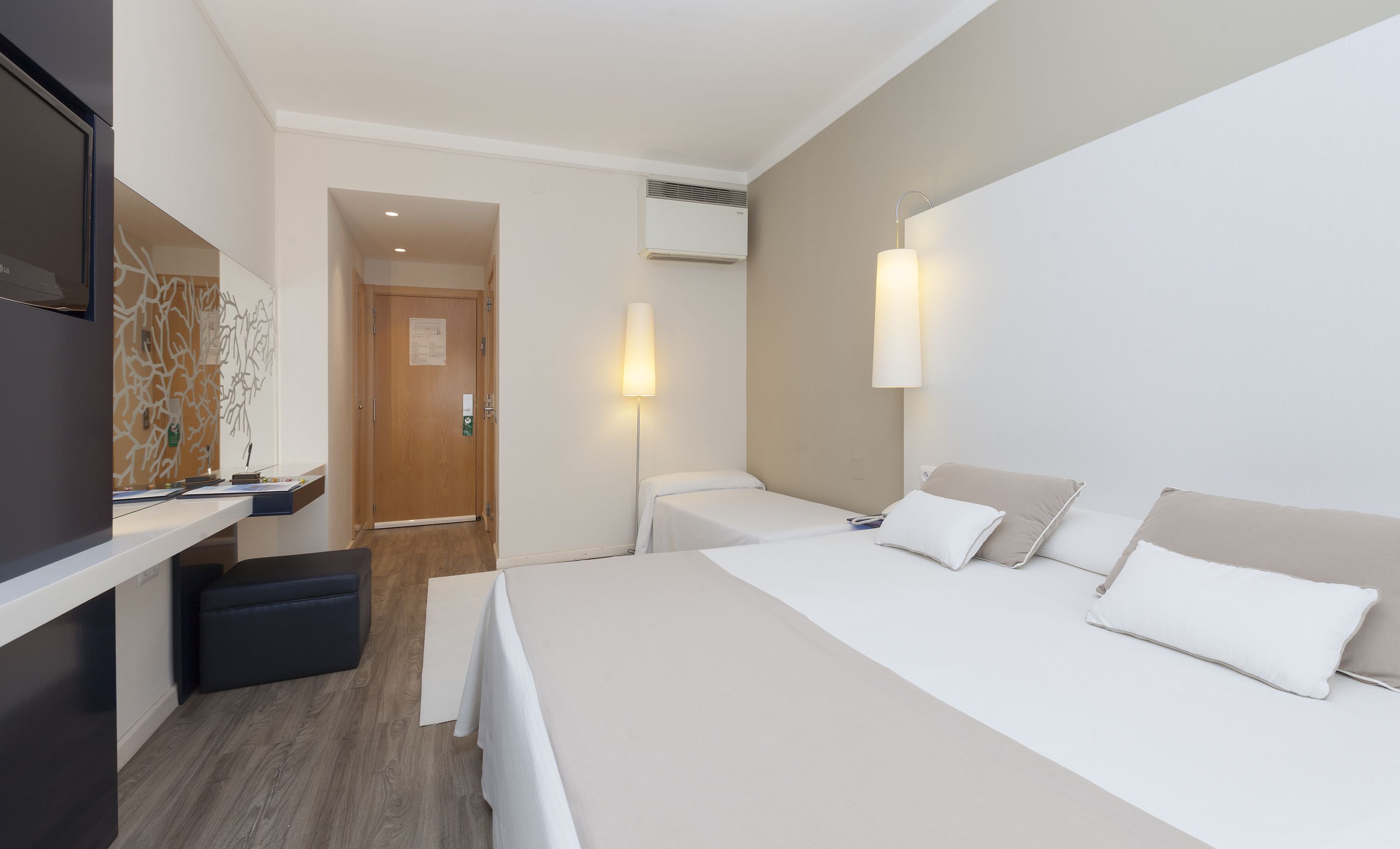 Een hotelkamer met een bed, nachtkastjes, een bureau en een stoel.