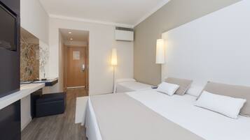 Een hotelkamer met een bed, nachtkastjes, een bureau en een stoel.