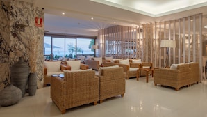 A spacious lobby with wicker furniture, a fire extinguisher, and a view of the outdoors. - Canyelles Platja (Roses)