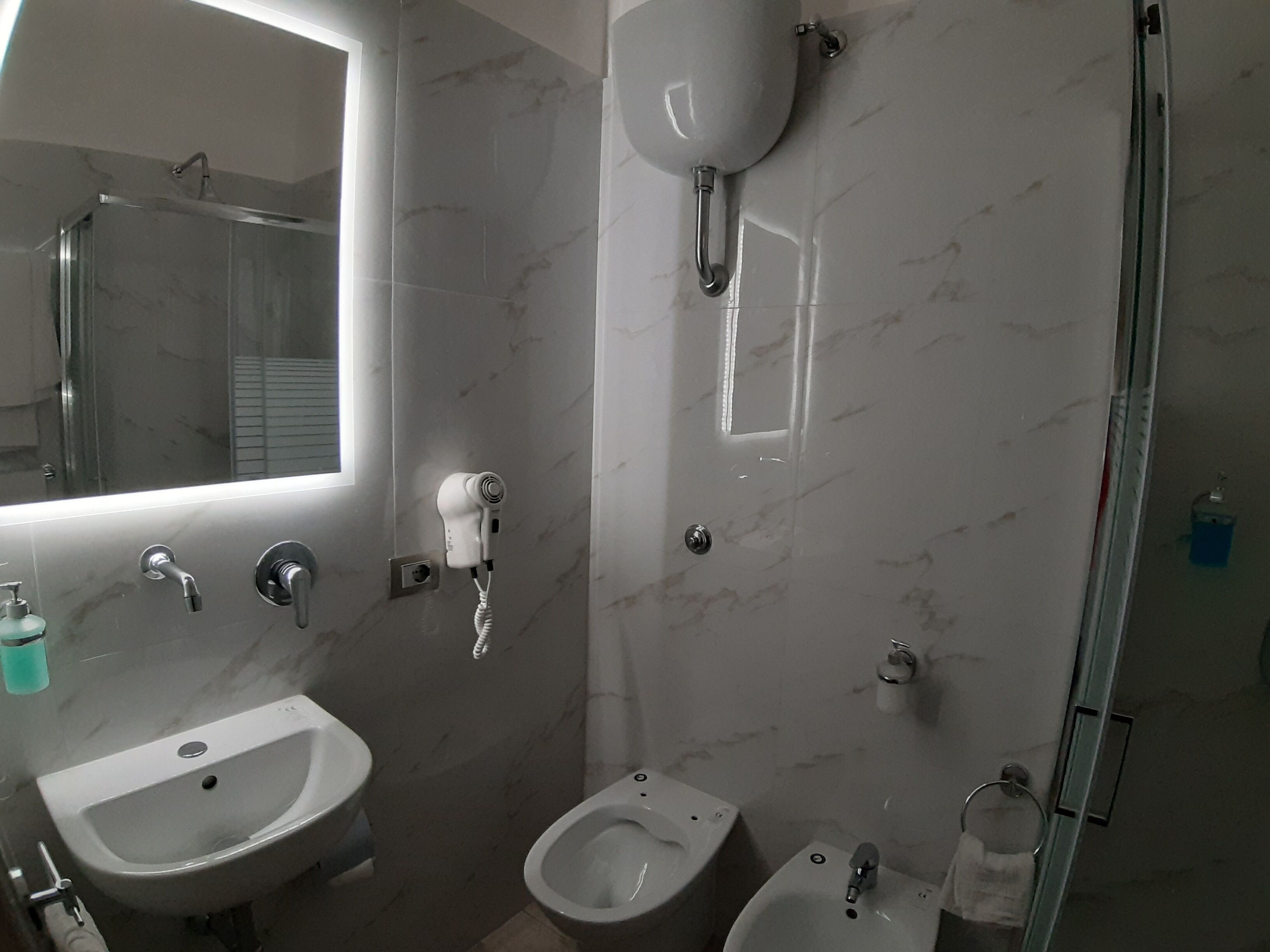 Une salle de bain moderne équipée d’un lavabo, d’un bidet et de toilettes.