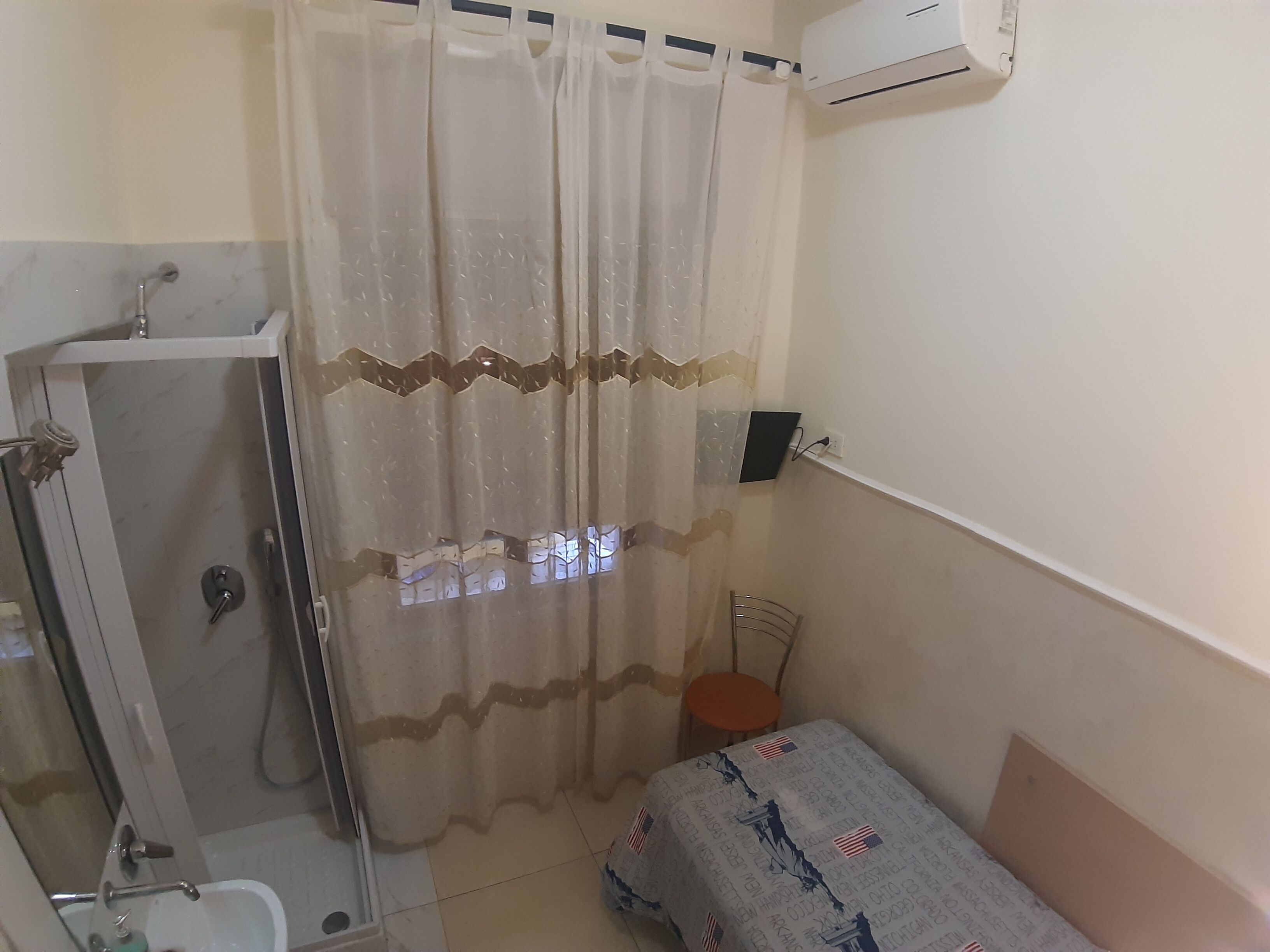 A small, compact bathroom with a shower, toilet, and sink.