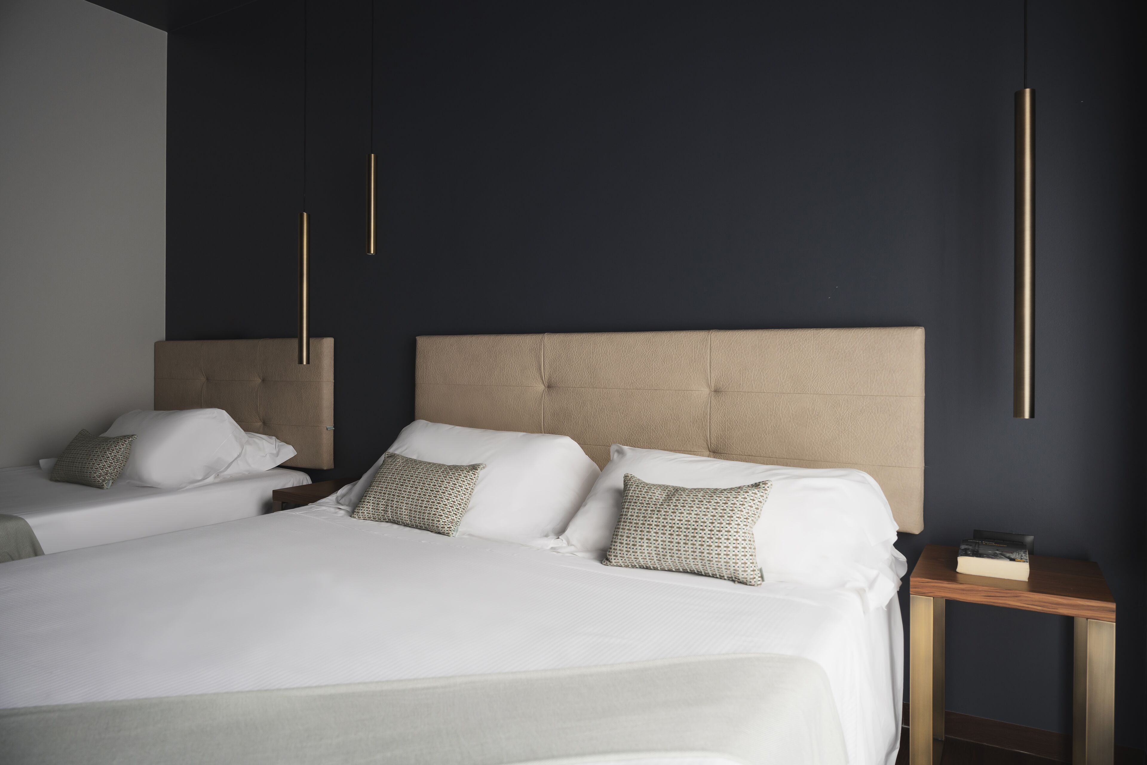 A modern bedroom with a large bed, two bedside tables, and a headboard.