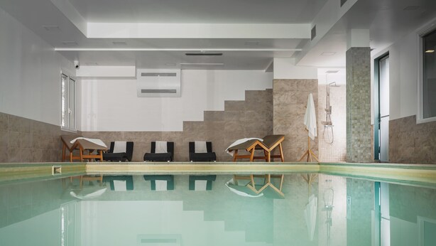 A swimming pool with lounge chairs and a shower area. - The Regent Boutique Hotel & SPA  (Borgo Maggiore)