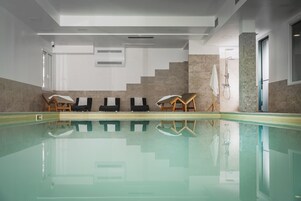 Piscina com espreguiçadeiras e área de chuveiro.