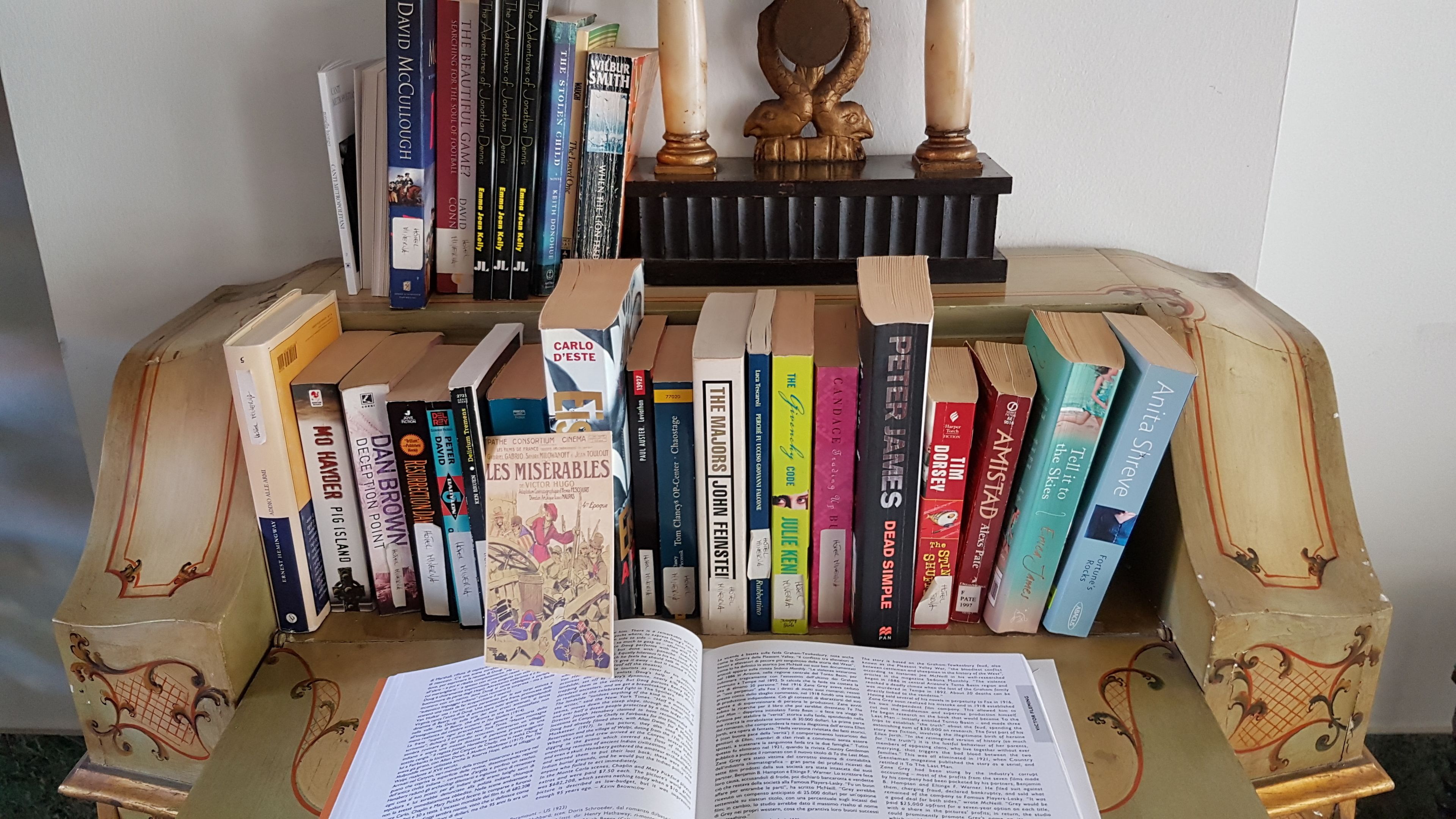 Ein Bücherregal voller Bücher und eine dekorative Holzkonstruktion mit einem offenen Buch davor.