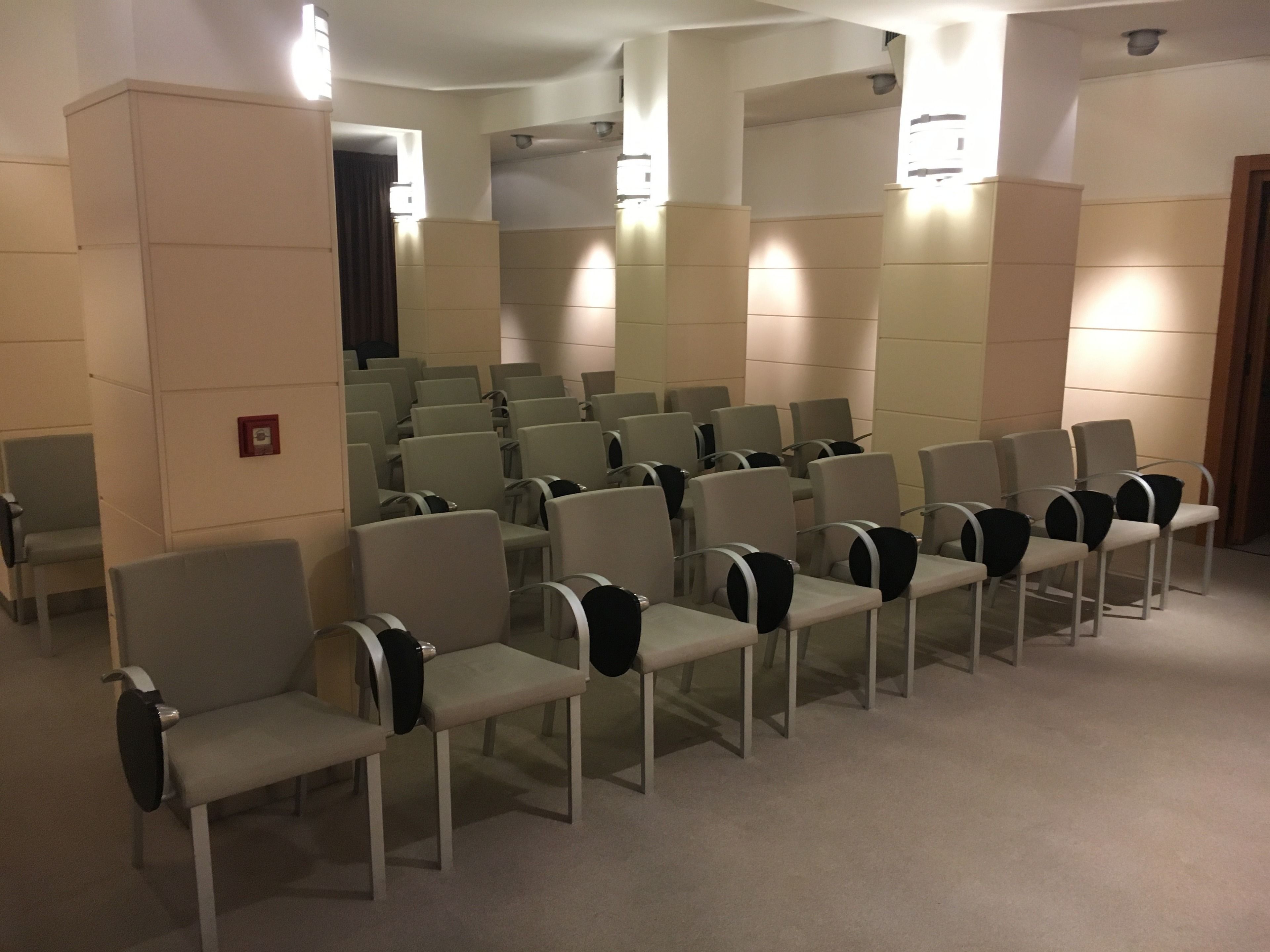 A waiting area with rows of chairs and a small stage.