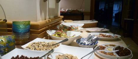 Una mesa de bufé con diversos alimentos y utensilios.