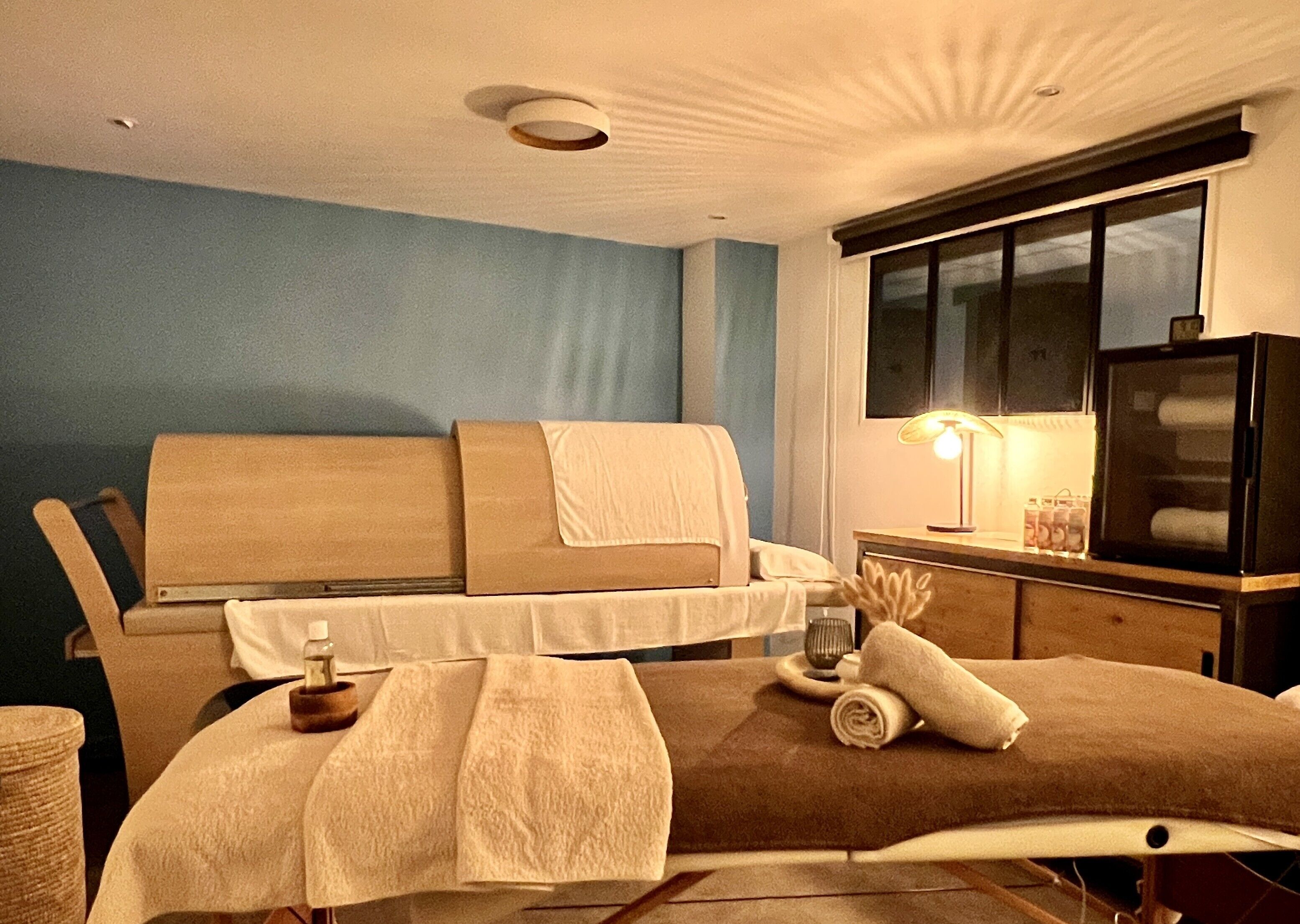 A modern bedroom with a bed, bedside table, lamp, and a television.