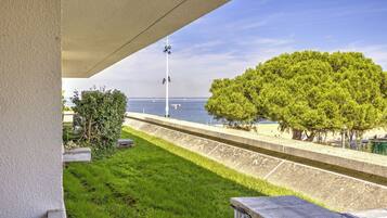 Un balcón con vistas al mar, un árbol y una farola.