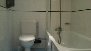 Une salle de bain équipée de toilettes, d’une baignoire et d’une douche.