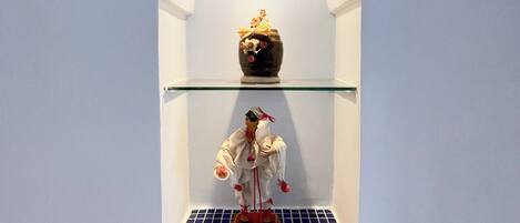 A shelf with a figurine, a decorative item, and a small table.
