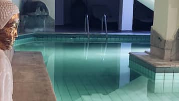 Area piscina con una statua, un orologio e una fontana.